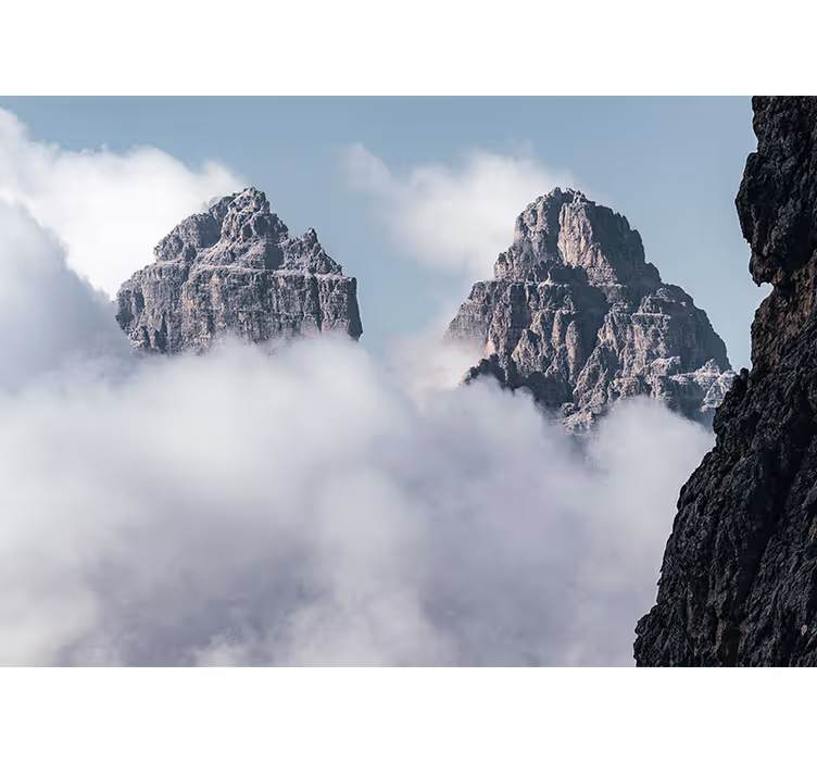 Papel mural montaña picos majestuosos sobre nubes - TenVinilo